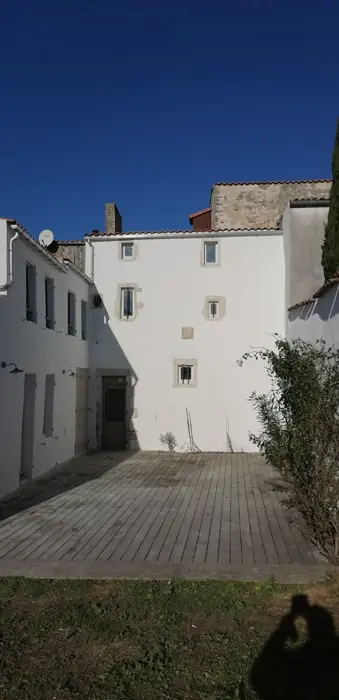 La même façade terminée, enduit blanc et encadrements en pierre (après)