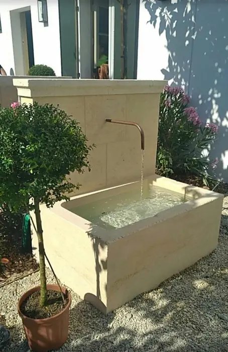 Fontaine en pierre avec bassin et bec en cuivre