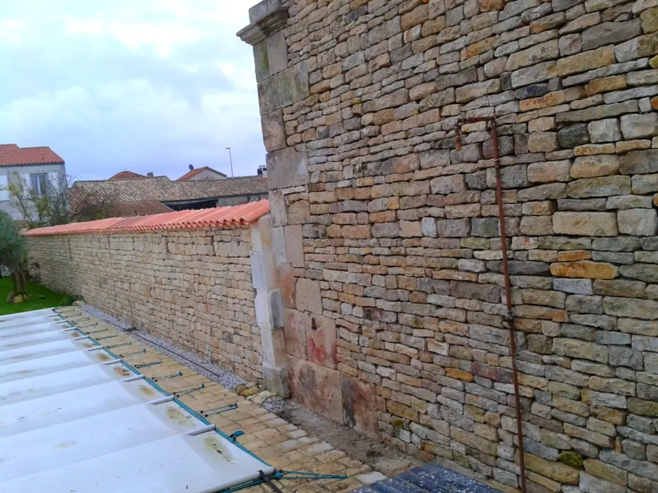 Mur en pierre sèche avec chaînage d'angle, en bordure de piscine